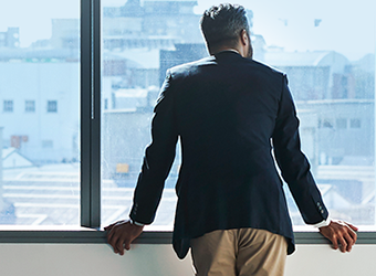 Man looking out window of office building